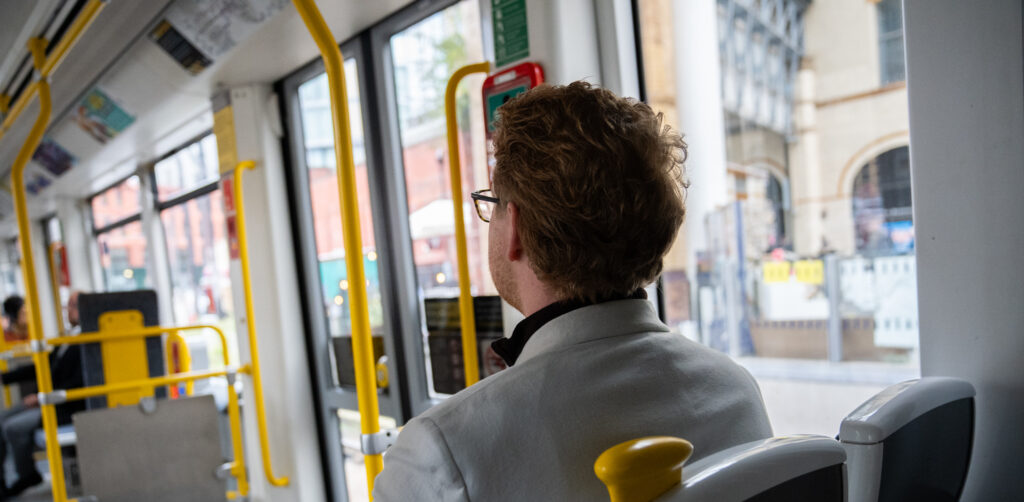 Cameron Linnell sitting on a Manchester tram.